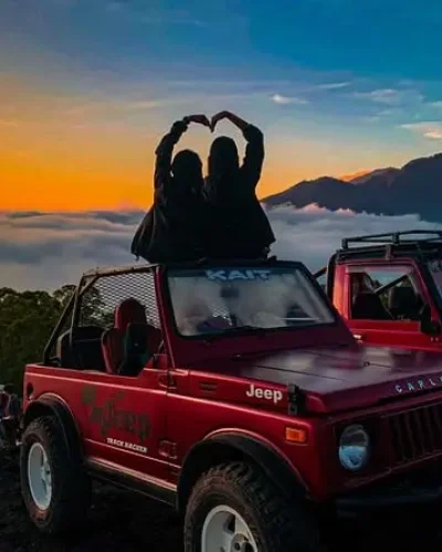 Pasangan dengan view gunung abang dan mobil jeep